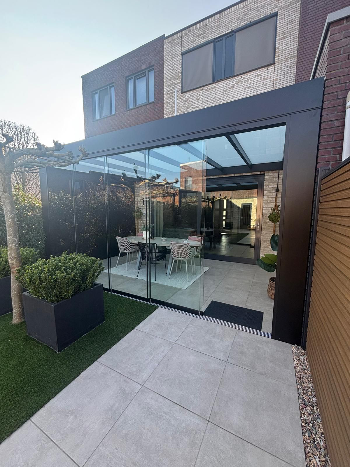 Luxe veranda met glazen wanden en moderne inrichting